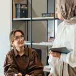 Work Autonomy - Two women in hijab talking in an office