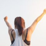 Motivated - Woman Wearing Black Bra and White Tank Top Raising Both Hands on Top