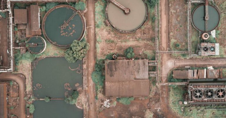 Clarifying - From above aerial view of industrial area of sewage treatment plant with round shaped water clarifiers