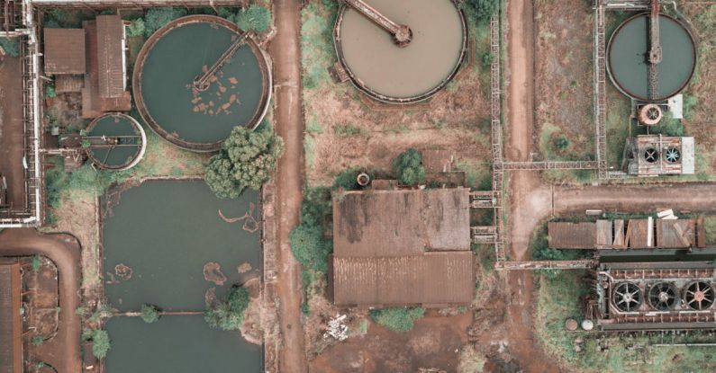 Clarifying - From above aerial view of industrial area of sewage treatment plant with round shaped water clarifiers